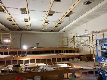 Commercial drywall installation with scaffolding and ceiling grid in progress