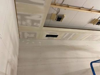 Smooth finished drywall ceiling with vent opening cut and edges detailed