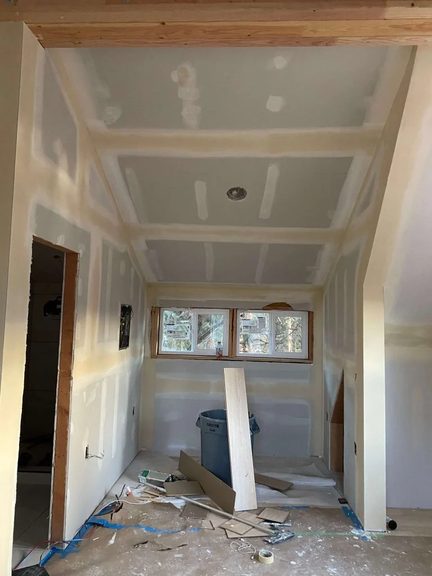 Vaulted room with taped and mudded drywall ready for finish coats