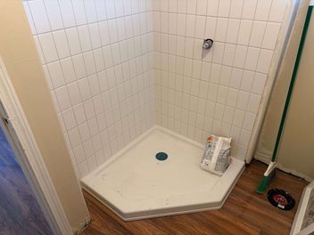 Corner shower pan and tile installation under a sloped bathroom ceiling