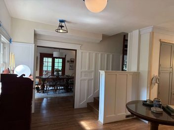 Finished interior with white cabinetry, paneled half wall, and hardwood flooring