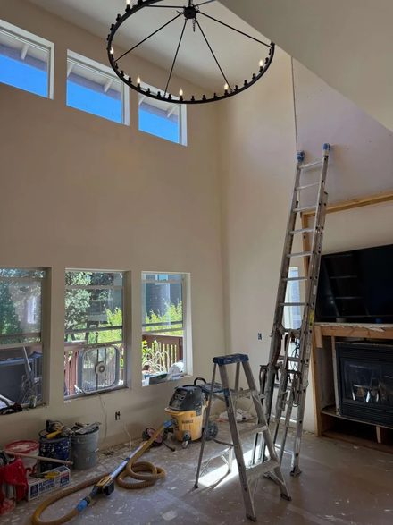 Vaulted great room during construction with clerestory windows and chandelier installed
