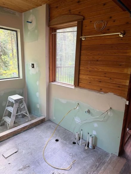 Bathroom remodel with moisture-resistant drywall and wood accent wall in progress